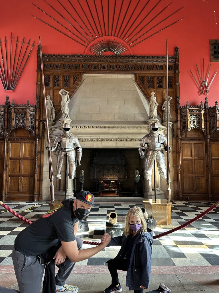 Father and daughter pose hard style in front of a massive fireplace in Edinburgh Castle in Scotland, UK